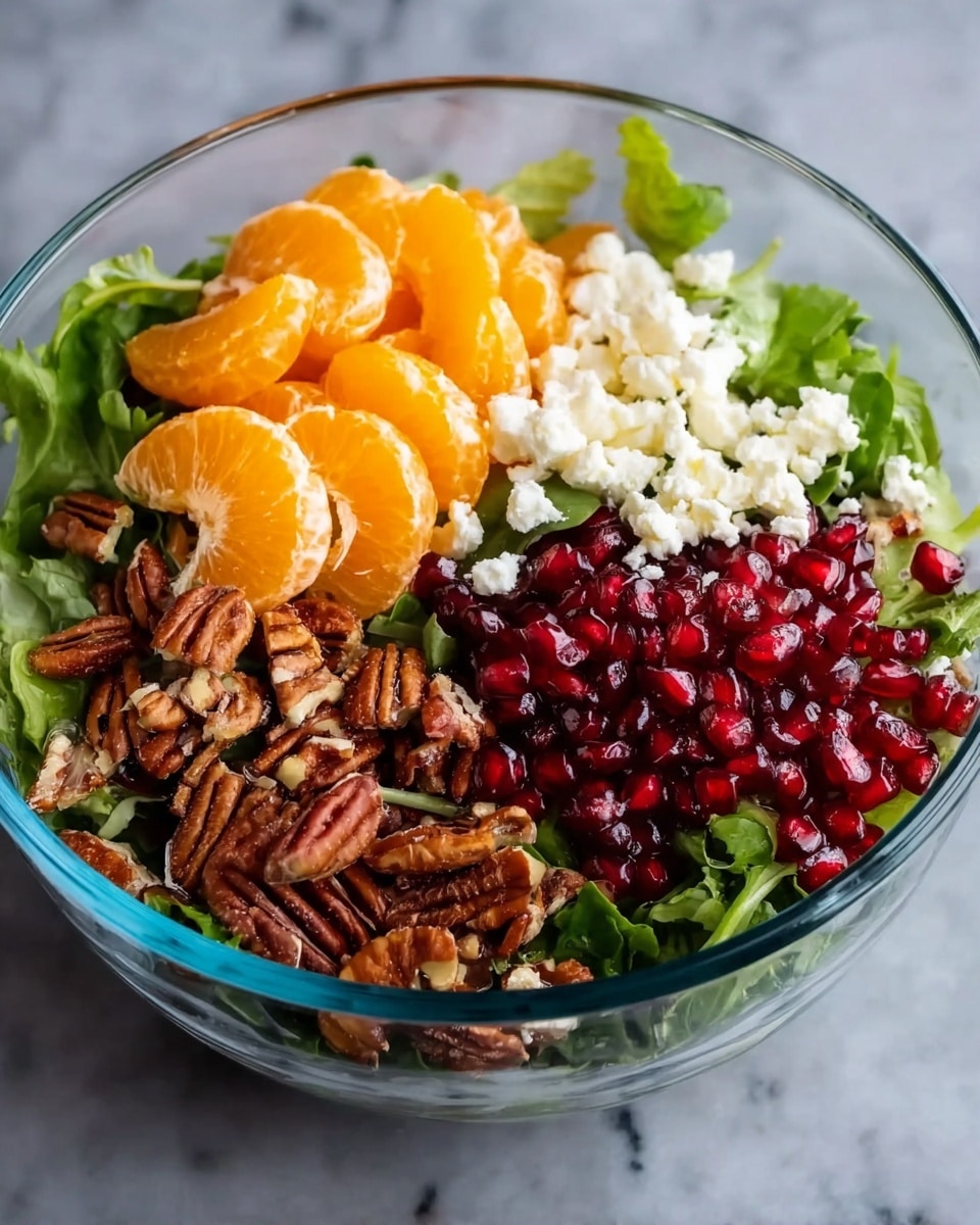 The image shows five clear glass bowls arranged on a white marbled surface. The largest bowl in the back is filled with fresh green mixed salad leaves showing different shades of green and leafy textures. In front of it, there are four smaller bowls: one contains bright orange mandarin segments with a smooth, shiny surface; another is filled with small white crumbled cheese bits; the third holds red pomegranate seeds that are shiny and juicy-looking; the last bowl contains brown pecan nuts with a rough texture and visible ridges. The bowls are neatly spaced and visually distinct by their colorful contents, photo taken with an iphone --ar 4:5 --v 7