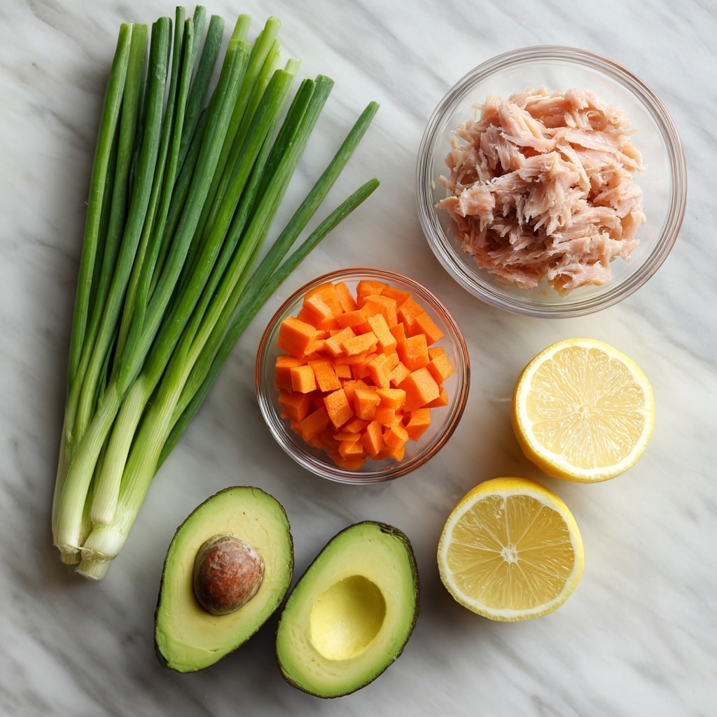 The image shows five main ingredients placed separately on a white marbled surface. At the top left, there is a bunch of long green onions with fresh deep green stalks and white roots. Below the green onions, on the left side, a small clear bowl contains bright orange diced carrots with a chunky texture. In the center, a medium clear bowl is filled with flakes of light pink tuna. To the right of the tuna bowl, there are two halves of a yellow lemon with visible juicy segments. At the bottom left, two halves of a green avocado are shown, one with the seed inside and the other with a smooth hollow where the seed was. The entire scene is naturally lit, with soft shadows, photo taken with an iphone --ar 4:5 --v 7