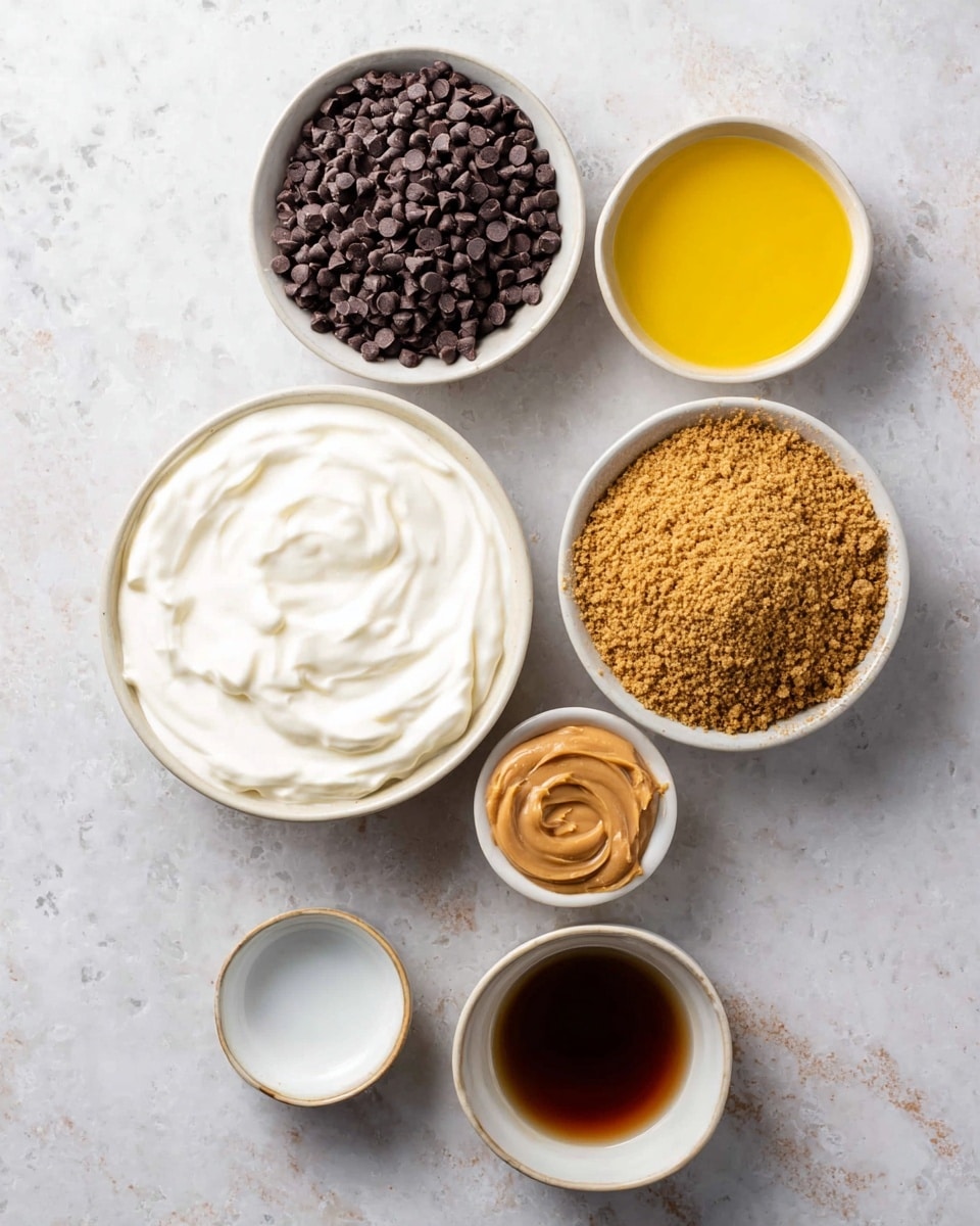 Top view of six small white bowls with ingredients arranged on a white marbled surface. The largest bowl is in the center holding smooth, thick white cream. Above it to the left is a bowl filled with small, dark brown chocolate chips, dense and piled high. To the right of the chips is a bowl with bright yellow melted butter. Below the cream, slightly left, is a bowl filled with fine brown graham cracker crumbs, showing a textured, grainy surface. To the right side, one small bowl holds light brown creamy peanut butter, and below it is another bowl filled with dark amber maple syrup, shiny and smooth. A very small empty white bowl is near the butter. photo taken with an iphone --ar 4:5 --v 7