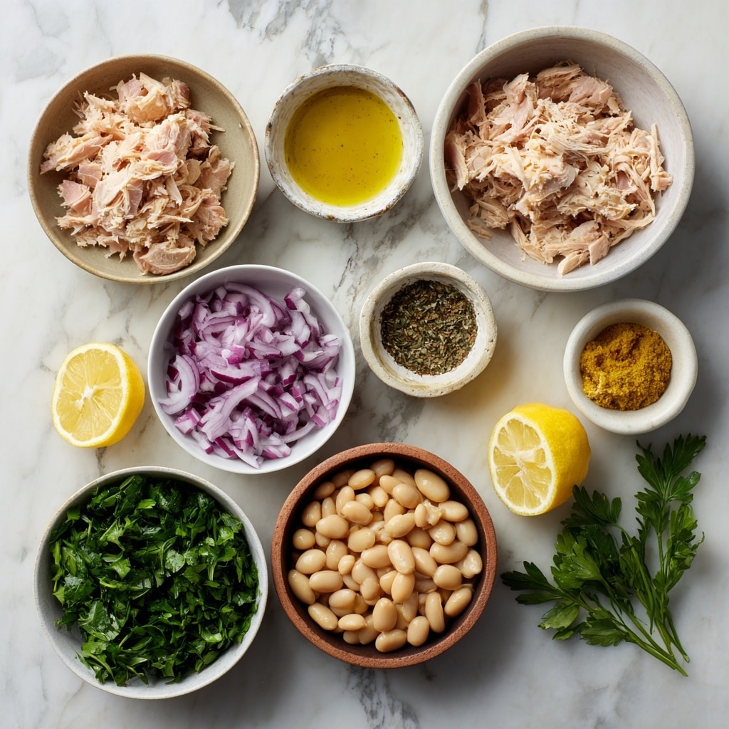 The dish shows a close-up of a mix of shredded light pink tuna layered with shiny white beans, small pieces of bright green chopped herbs, and bits of light purple onion, all piled on a white plate. The tuna looks soft and flaky, sitting on top and mixed with the beans and herbs that add pops of green and purple colors. A silver fork holds some of this mixture, positioned at the bottom right corner, with a few beans and herbs visible on the fork. The surface under the plate is white marble, creating a clean and fresh background. Photo taken with an iphone --ar 4:5 --v 7