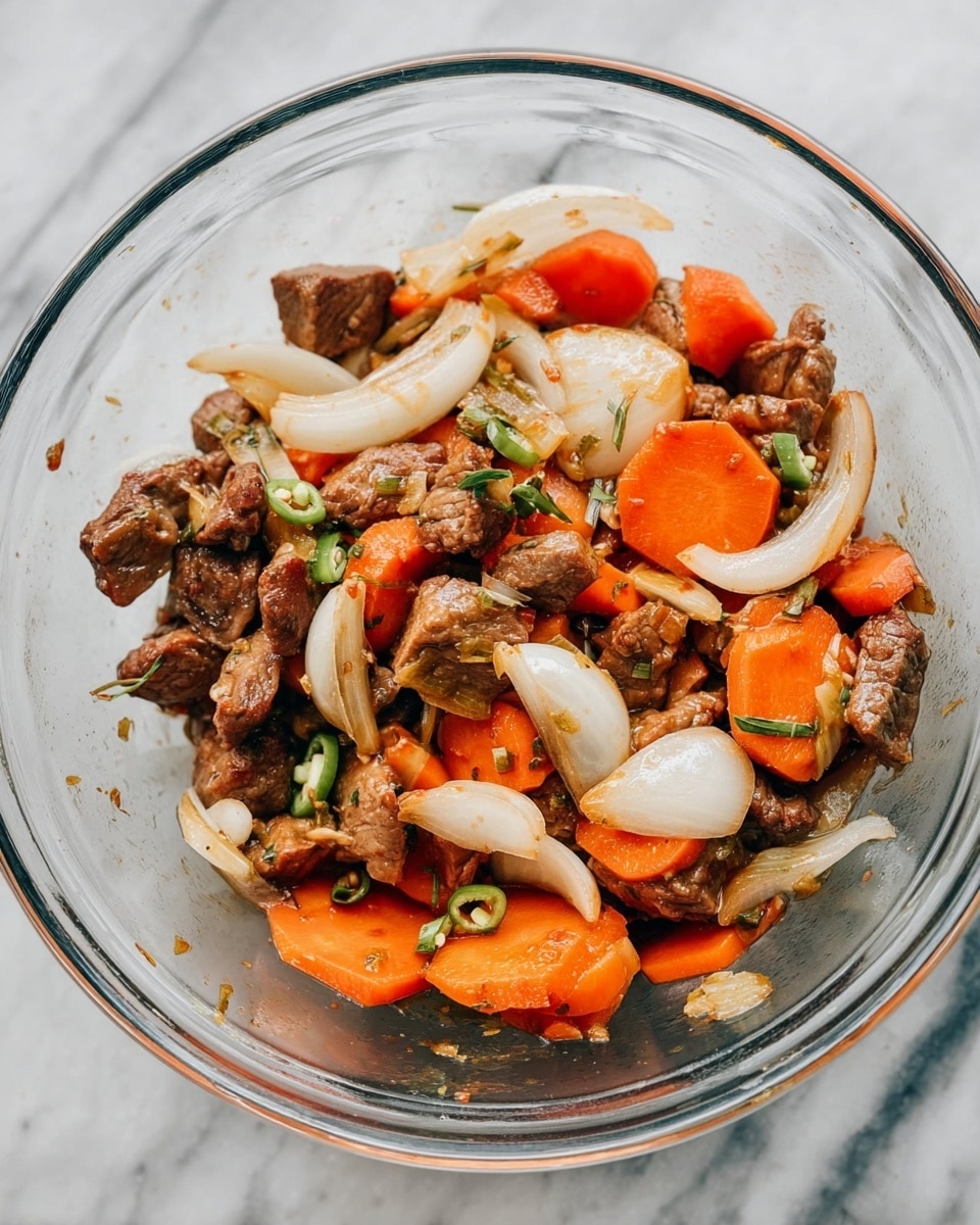 A clear glass bowl filled with cooked pieces of brown meat mixed with bright orange sliced carrots and translucent white onion slices, along with a few small green chili pieces scattered throughout. The ingredients are mixed but still show distinct layers of meat, vegetables, and herbs. The bowl is set on a white marbled texture. photo taken with an iphone --ar 4:5 --v 7