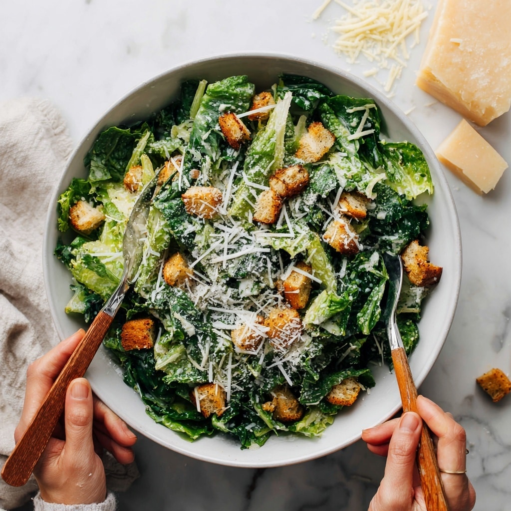 A white bowl filled with a fresh green leafy salad forms the base layer, topped with small golden-brown crunchy croutons scattered evenly. The salad is sprinkled with a fine layer of white shredded cheese. Two woman’s hands hold wooden-handled forks poised on opposite sides of the bowl. The whole scene is set on a white marbled surface with extra shredded cheese and cheese blocks placed on the top right. Photo taken with an iphone --ar 4:5 --v 7