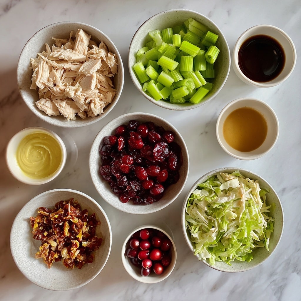 A golden brown croissant sliced in half shows layers of crispy, flaky texture on top and bottom. Inside, bright green leafy lettuce forms the bottom layer, looking fresh and slightly curled. Above the lettuce, there are creamy chunks of light beige chicken salad mixed with small green celery pieces and dark red dried cranberries, which add color contrast and texture. The croissant sandwich sits on a wooden board against a white marbled surface background. photo taken with an iphone --ar 4:5 --v 7