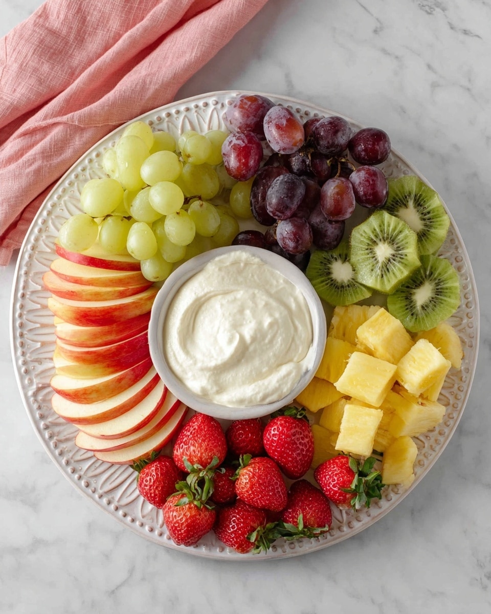 A round white bowl filled with creamy, smooth white dip sits in the middle of the image, surrounded by colorful fresh fruit. Around the bowl are slices of red and yellow apple with some light shine, clusters of green and purple grapes, bright red strawberries with green leaves, green kiwi slices showing their small black seeds, and chunks of yellow pineapple. All the fruit pieces are placed neatly close to the bowl on a white marbled surface, making the colors stand out. photo taken with an iphone --ar 4:5 --v 7