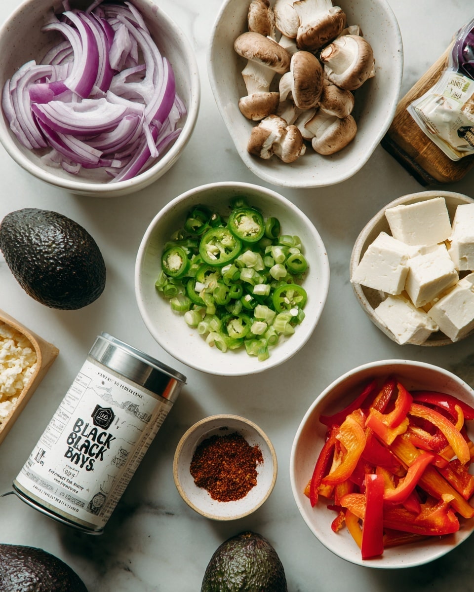 The image shows a white marbled surface with seven white bowls and a can arranged neatly. One bowl contains thinly sliced light purple red onions, another holds bright green chopped jalapeño pieces. A third bowl is filled with small brown and white baby bella mushrooms, while a fourth contains thick white cubes of extra firm tofu. Next to them, a bowl has red and orange sliced bell pepper strips. A small white bowl holds a mix of red chili powder, dark red chipotle chili powder, brown cumin, reddish smoked paprika, and white salt. A whole dark green avocado and a silver can of black beans labeled