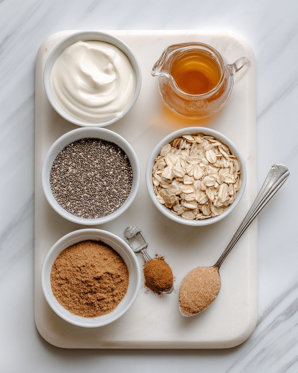 The image shows a white marble board with six small white bowls and a small clear glass jug arranged neatly on it. Each bowl contains one ingredient: grey chia seeds with a tiny bit of white, creamy off-white dairy free yogurt with a smooth texture, light brown oats with a dry and flaky look, a light brown powder of cinnamon on a small silver spoon, and light brown granulated sweetener shaped into small scoops. The small clear glass jug holds a warm amber-colored vanilla liquid. The background is a white marbled texture. photo taken with an iphone --ar 4:5 --v 7