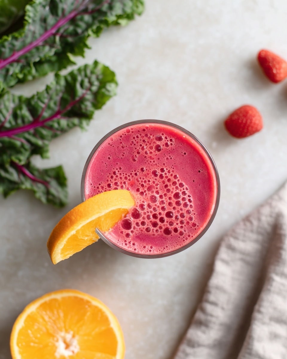 A glass filled with a bright pink smoothie topped with small bubbles covers the entire surface. On the rim of the glass, there is a wedge of orange with bright orange skin and yellow flesh, placed on the left side. The glass is set on a white marbled surface. To the bottom left, there are fresh dark green leaves with purple stems spread out, and on the bottom right, a light gray cloth holds a halved orange showing its orange inner flesh. In the upper right corner, three small red strawberries are scattered on the surface. Photo taken with an iphone --ar 4:5 --v 7