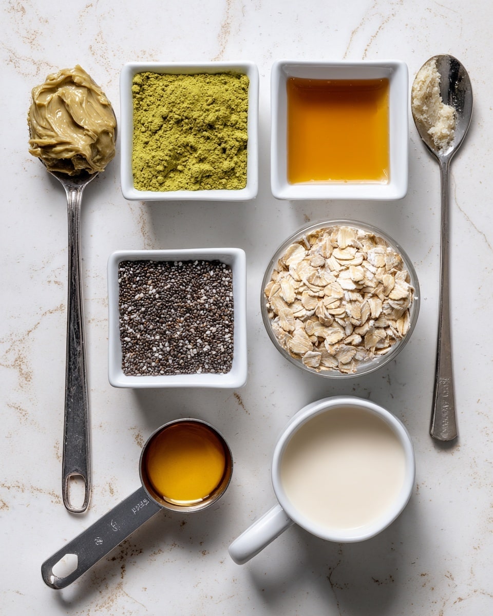 The image shows seven measuring spoons and cups with different ingredients placed on a white marbled surface. From top left to right: one tablespoon of pistachio butter in a metal spoon, a square white bowl with amber vanilla extract, and a quarter teaspoon metal spoon with bright green matcha powder. Below these, a square white bowl filled with tiny black chia seeds, a rounded metal spoon with thick golden maple syrup, a half-cup metal measuring cup with beige quick oats, and a white half-cup measuring cup filled with off-white non-dairy milk. Soft shadows fall across the surface. Photo taken with an iphone --ar 4:5 --v 7