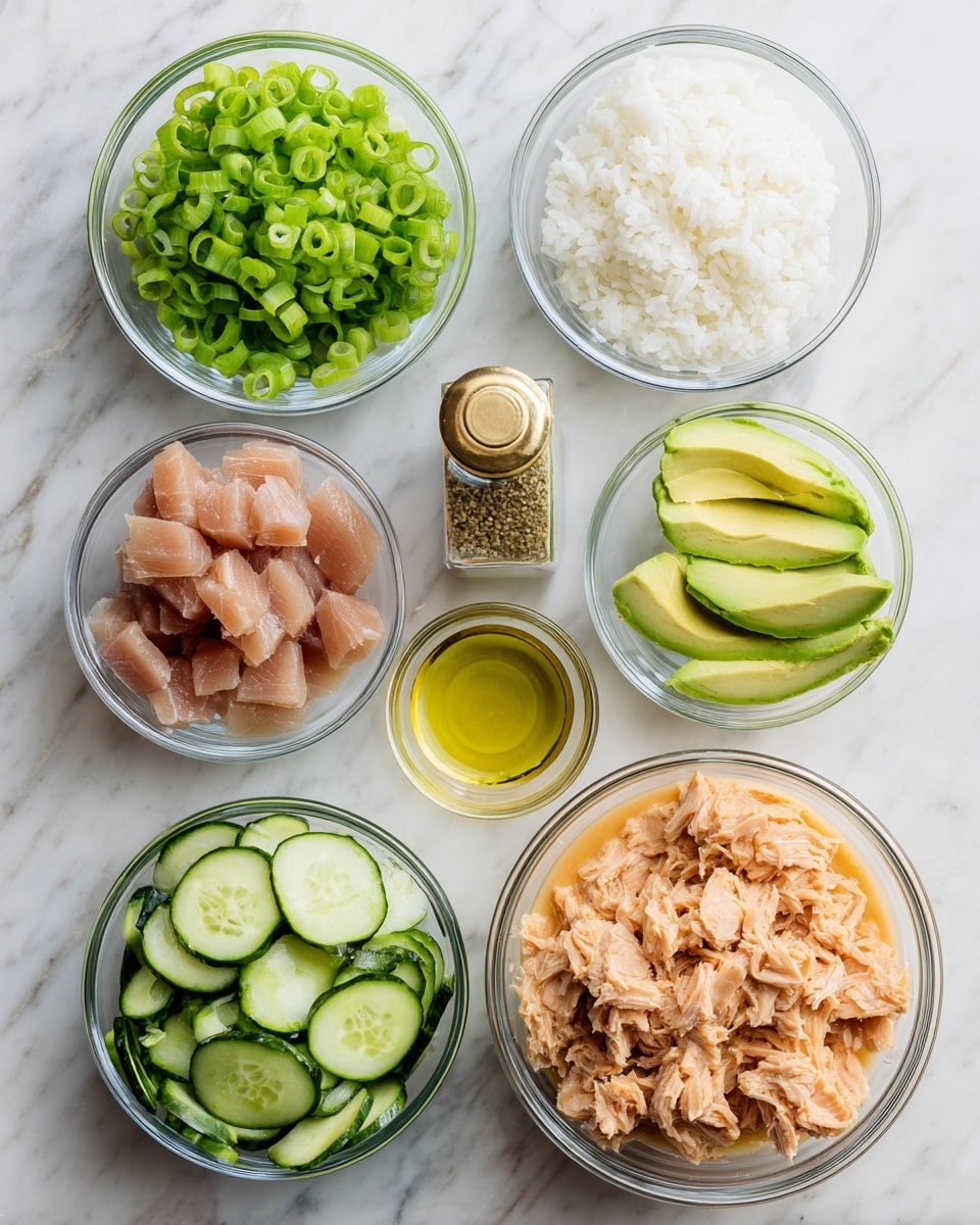 The image shows seven clear bowls arranged on a white marbled surface. The top row has three bowls: finely sliced bright green spring onion on the left, white fluffy sushi rice in the middle, and thin, light green avocado slices on the right. In the middle is a small bottle of furikake seasoning with a gold cap and a tiny glass with pale yellow olive oil. Below, there are two larger bowls: on the left, a mix of chopped cucumber salad with sliced cucumber pieces and some dark rings, and on the right, a bowl filled with thick, smooth, orange bang bang sauce. To the left of the sauce bowl is another bowl filled with light pinkish-tan chunks of tuna. All bowls are clear glass with visible layers, and the background is a clean white marble. Photo taken with an iphone --ar 4:5 --v 7