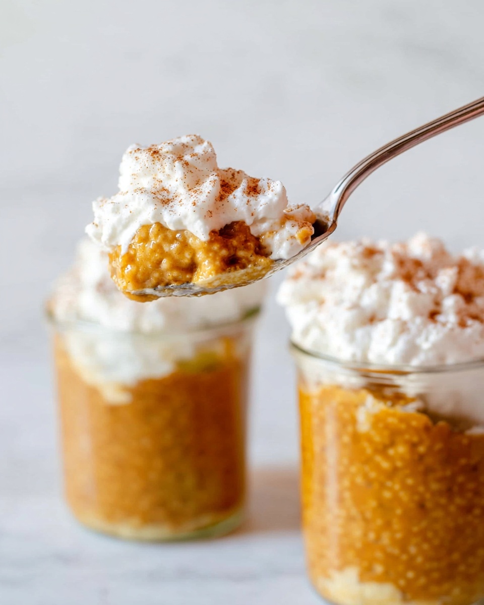 The image shows two clear glass jars filled with a thick, caramel-colored pudding-like dessert that has a slightly bumpy texture. Each jar is topped with a generous layer of fluffy white whipped cream, sprinkled with a light dusting of brown spice, possibly cinnamon. In the foreground, a silver spoon holds a scoop of the dessert layered with the whipped cream, showing the rich, dense pudding below and the soft whipped cream above. The background is a clean white marbled texture. Photo taken with an iphone --ar 4:5 --v 7