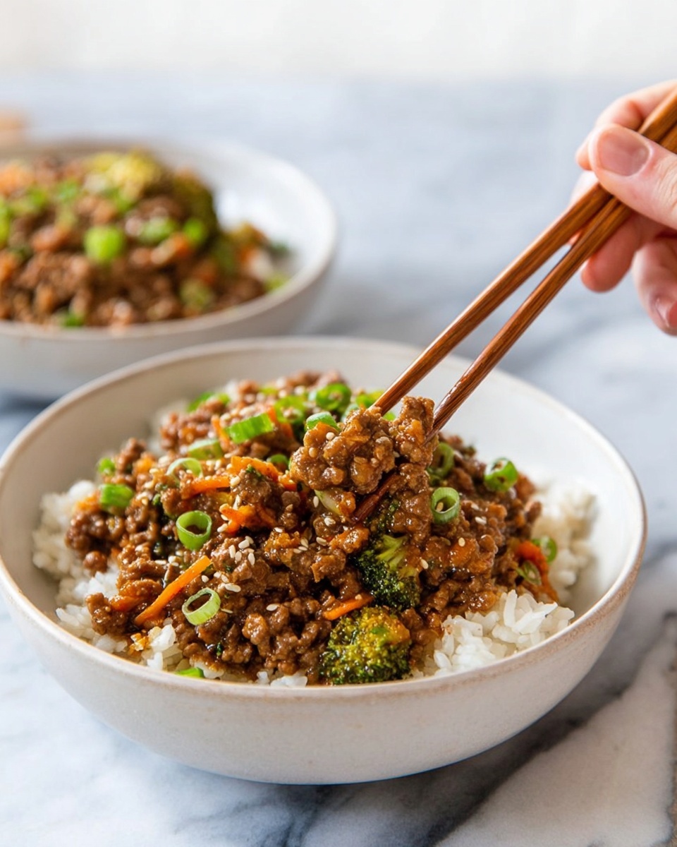 A white bowl is filled with a base layer of cooked white rice showing soft, fluffy grains. On top, there is a thick layer of ground meat mixed with small pieces of green broccoli, bright orange carrot strips, and chopped green onions scattered throughout. The sauce covering the meat looks slightly glossy and brown, with some sesame seeds sprinkled on top for texture. In the top right, a woman's hand holds wooden chopsticks picking up a bit of the meat mixture. The background shows another white bowl with the same dish slightly out of focus, on a white marbled surface. photo taken with an iphone --ar 4:5 --v 7