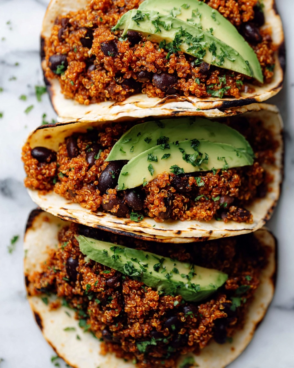 The image shows three small white tortillas arranged side by side on a white marbled surface. Each tortilla is filled with a warm layer of reddish-orange cooked quinoa mixed with black beans, giving a textured appearance with small round grains and dark beans. There are thin green slices of avocado placed diagonally inside the tortillas, adding a smooth, fresh green layer next to the quinoa beans mixture. A light sprinkling of chopped green herbs is scattered over the top of the fillings and around the tortillas, enhancing the color contrast. The tortillas have slight grill marks and curled edges, creating a rustic look. photo taken with an iphone --ar 4:5 --v 7