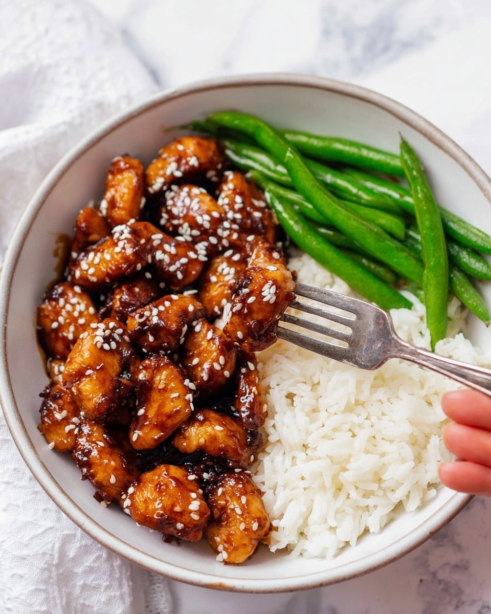 A white bowl contains three parts: white cooked rice filling roughly half of the bowl on the right side; glossy brown glazed chicken pieces seasoned with sesame seeds piled in the left half, some of which are speared by a silver fork held by a woman's hand; and a small stack of bright green cooked beans placed beside the chicken at the bottom right side. The bowl sits on a white marbled surface. Photo taken with an iphone --ar 4:5 --v 7