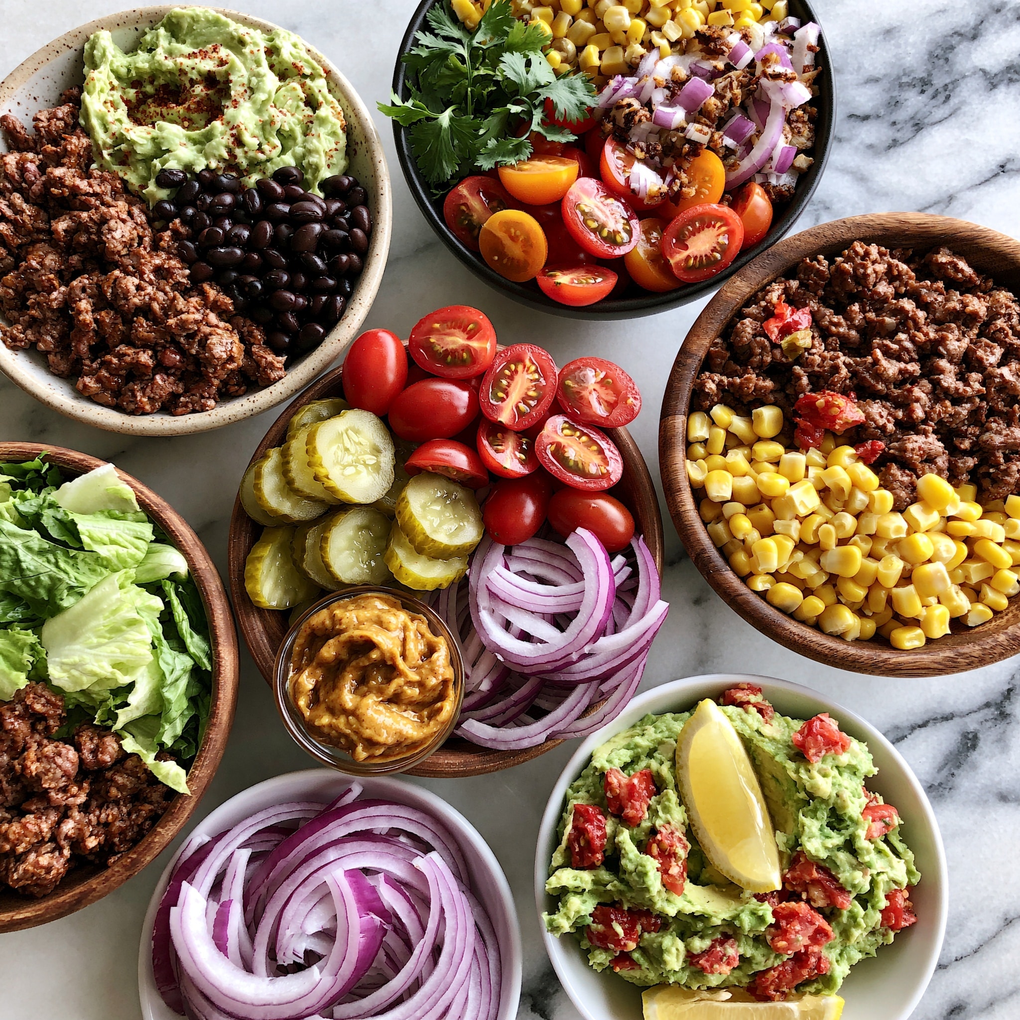A white bowl filled with a layered salad starting at the bottom with fresh green lettuce leaves that appear crisp. On top, there are bright red halved cherry tomatoes mixed with light green sliced pickles with ridges. Next, light brown cooked ground beef sits in the center, surrounded by golden brown cooked strips of another meat. There are also thinly sliced pale onions scattered on the sides. A large dollop of green guacamole rests on one side, and a light pink creamy dressing is drizzled evenly over the entire salad. The bowl is placed on a wooden surface with halved avocados and cherry tomatoes scattered around. Photo taken with an iphone --ar 4:5 --v 7