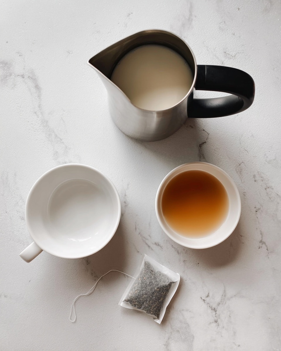 The image shows a white mug at the bottom left empty, and a small white bowl to the right holding a light brown liquid. Above these, there is a metal jug with a black handle containing a small amount of white liquid. Next to the jug, a wet tea bag with a white paper tag lies on the white marbled surface. All items are placed neatly on the white marbled background, showing a simple and clean setup. photo taken with an iphone --ar 4:5 --v 7