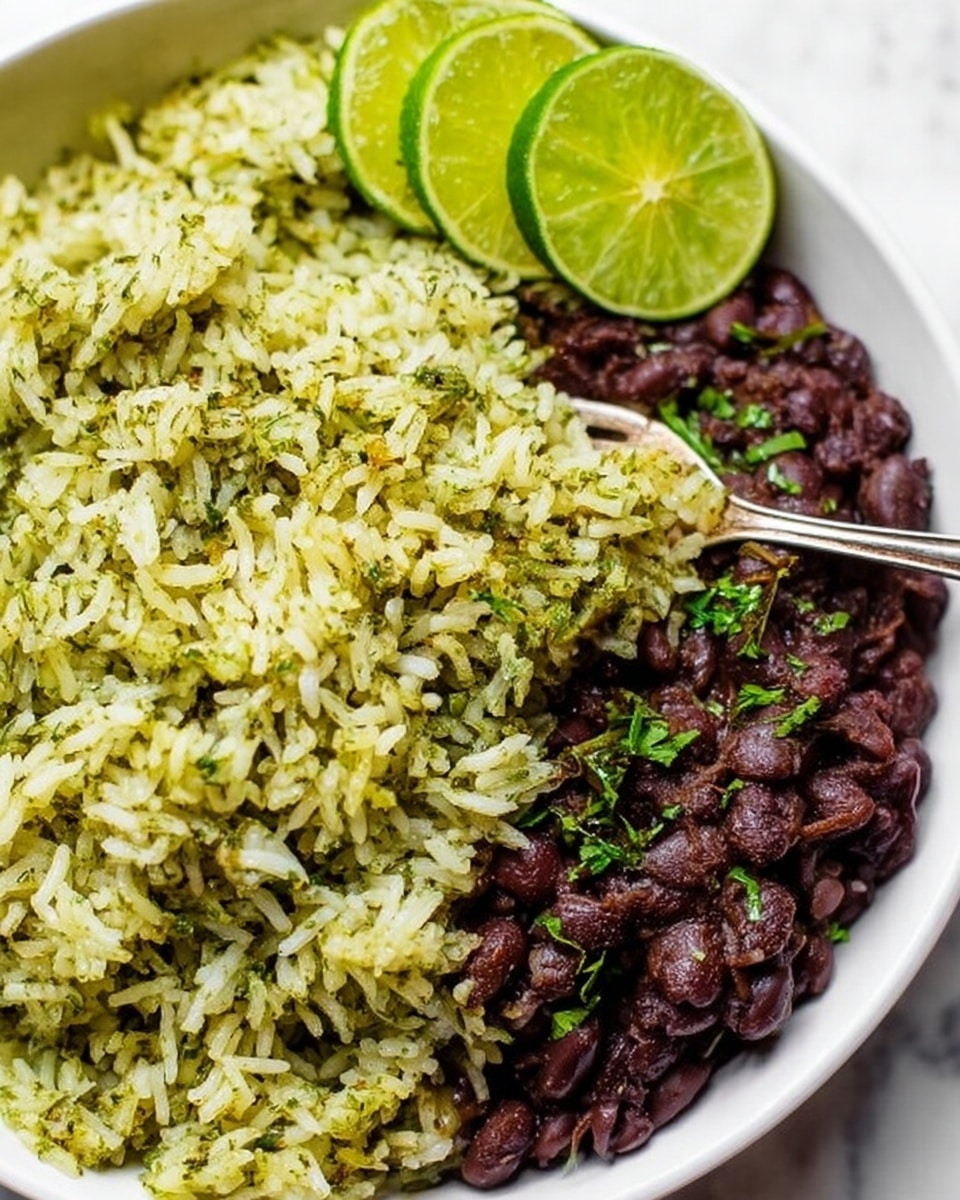 The image shows a white bowl filled with two main layers: on one side, there is a pile of green-tinted rice mixed with herbs, giving it a fluffy texture with small green bits spread throughout, and on the other side, there is a portion of dark brown beans that look thick and soft with a few small green herbs scattered on top. Along the edge of the bowl, there are thin slices of bright green lime arranged neatly in a curved line. A silver fork is partially stuck into the rice, with the tip touching the grains. The bowl is set on a white marbled surface. photo taken with an iphone --ar 4:5 --v 7