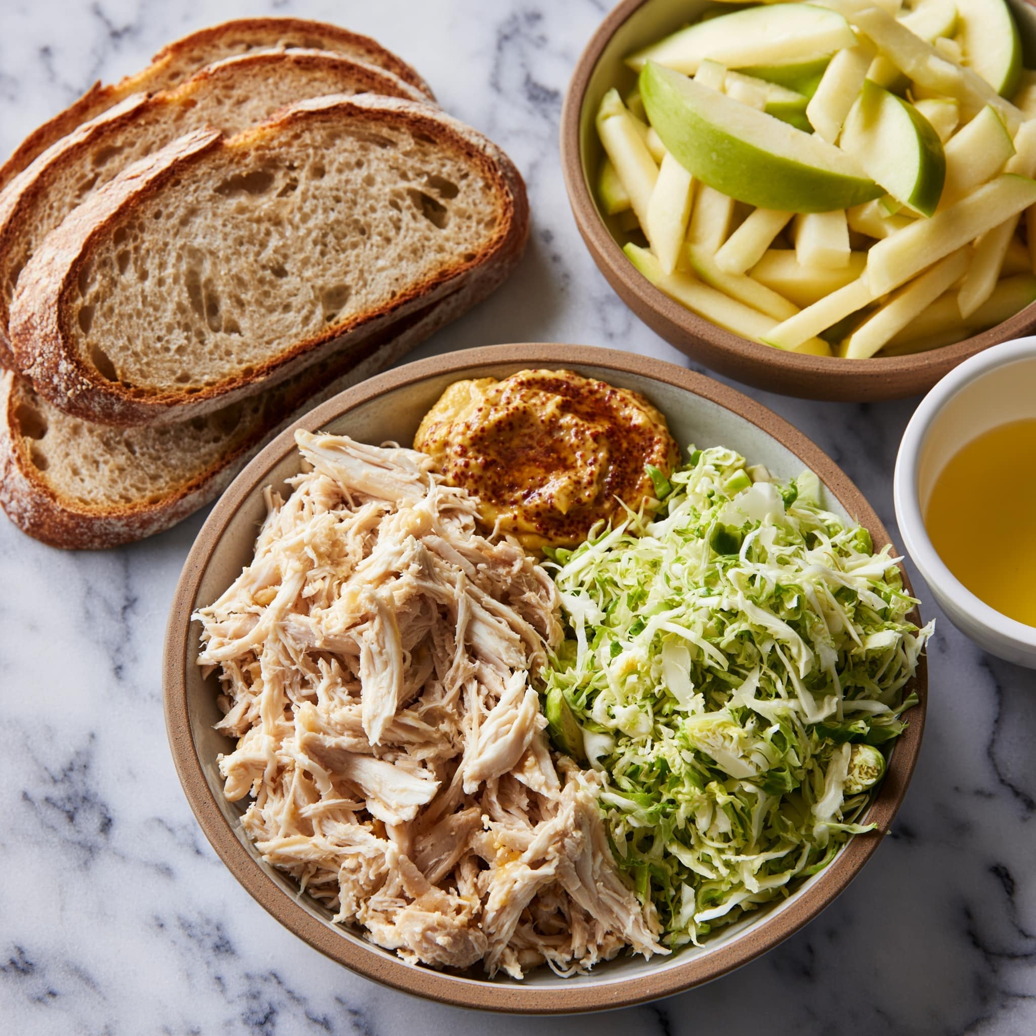 The image shows eight slices of toasted bread placed on a metal tray resting on a white marbled surface. Four slices are topped with melted cheese that is creamy and light yellow, covering the surface unevenly with holes and bubbles visible. The other four slices are topped with shredded light brown chicken, thin sticks of pale yellow apple, and finely chopped green lettuce with some red radish strips scattered among the greens. The layers create a fresh and colorful contrast against the toasted bread, with the chicken and fresh veggies piled loosely on each slice Photo taken with an iphone --ar 4:5 --v 7
