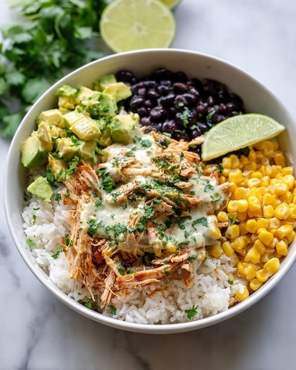 A white bowl on a white marbled surface holds a colorful rice bowl with five main layers arranged in sections. At the base is a layer of white rice. On top of the rice near the center is shredded cooked chicken mixed with light green sauce and sprinkled with chopped herbs. To the left of the chicken is a section of black beans, and to the right is a section of bright yellow corn. On the top left side of the bowl is diced avocado in small chunks. A wedge of lime sits on the right side of the chicken layer. The background shows a wedge of lime and some cilantro leaves. Photo taken with an iphone --ar 4:5 --v 7