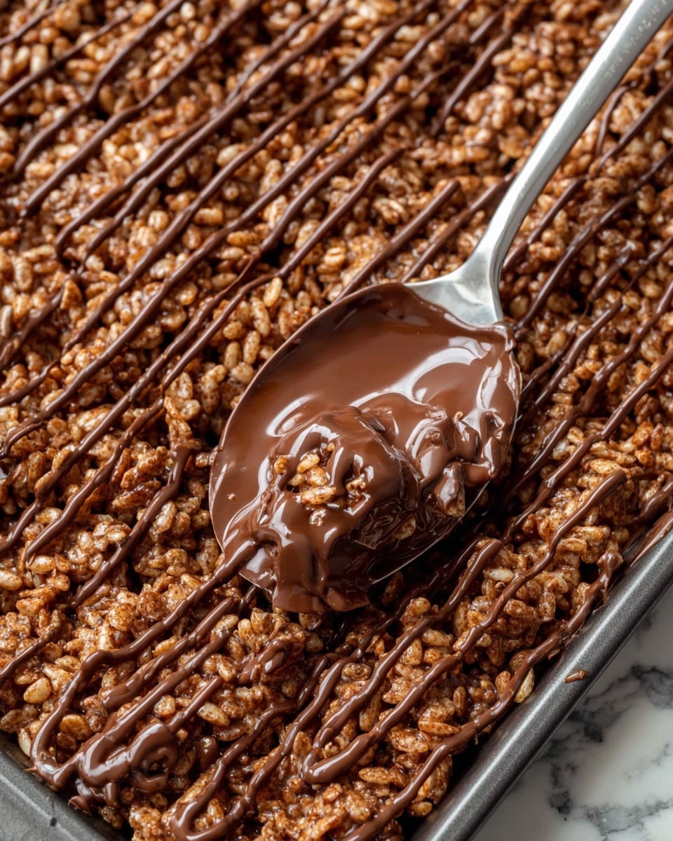 The image shows a close-up of a large tray filled with crispy rice cereal mixed with melted chocolate, forming an uneven but thick layer. On top, there are darker melted chocolate lines drizzled in a random pattern, adding a shiny and smooth texture contrast to the rough cereal below. A metal spoon with a rounded scoop is placed on the tray, coated in glossy melted chocolate, highlighting its creamy texture. The background is a white marbled surface, making the rich brown colors of the treat stand out clearly. photo taken with an iphone --ar 4:5 --v 7