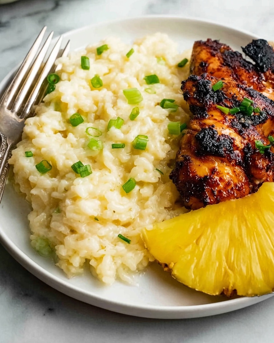 The image shows a white plate with three main layers: a base layer of creamy, pale yellow risotto with a soft, slightly lumpy texture, topped with small green chive pieces scattered across. To the right of the risotto sits a piece of grilled, dark brown chicken with char marks and a glossy finish, garnished with a few green herbs. Next to the chicken, on the far right edge of the plate, is a thick slice of fresh pineapple with bright yellow flesh and a slightly rough texture. A silver fork rests on the left side of the plate, all set against a white marbled surface. photo taken with an iphone --ar 4:5 --v 7